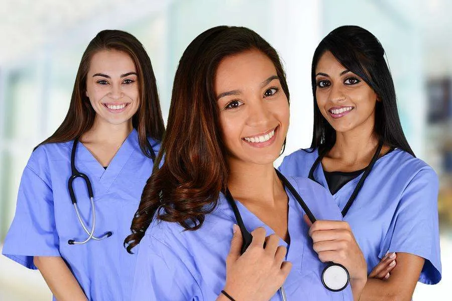 Three female nurses are shown in a close-up, posed portrait.