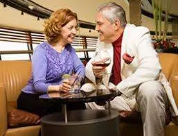 Full indoor shot of a couple seated at a small table in a lounge.